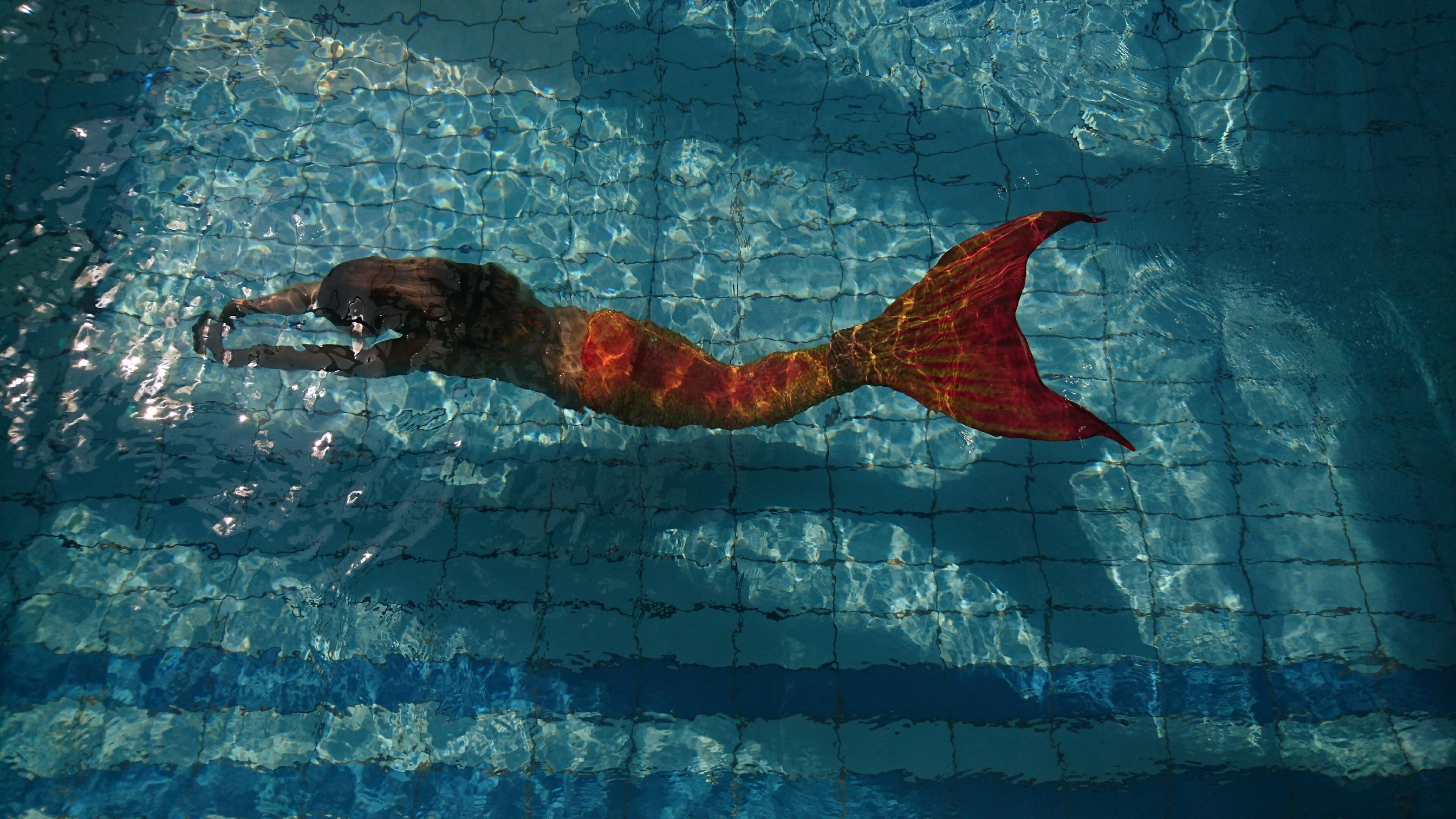 Instruktorka a účastnice kurzu mořských panen v bazénu